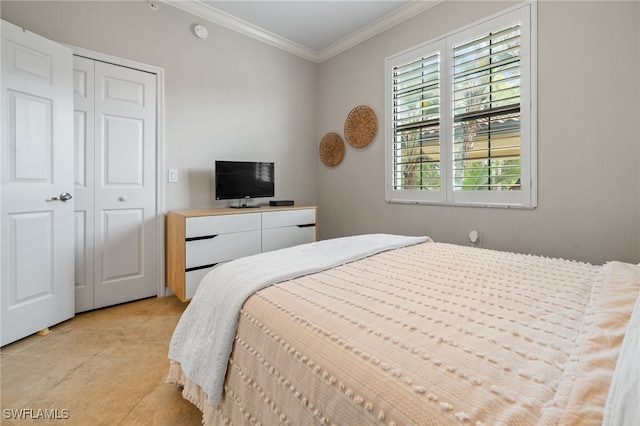 bedroom with light tile patterned flooring, crown molding, and a closet