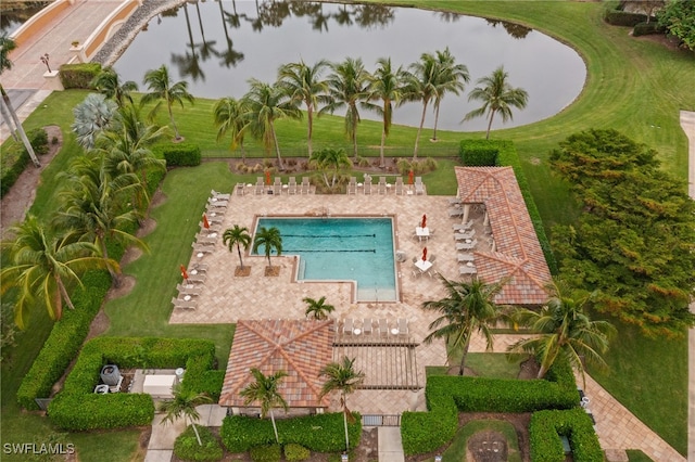 view of pool featuring a patio area, a water view, and a yard