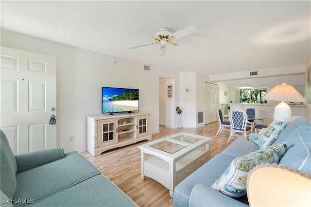 living room featuring ceiling fan and light hardwood / wood-style flooring