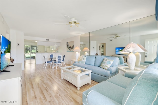 living room with ceiling fan and light wood-type flooring