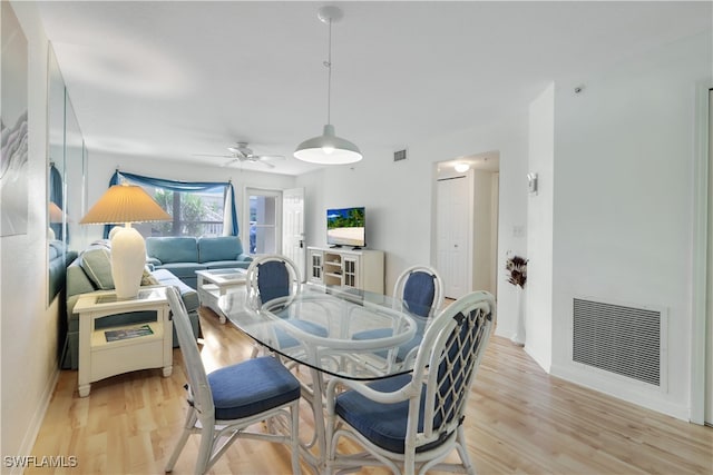 dining space with ceiling fan and light wood-type flooring