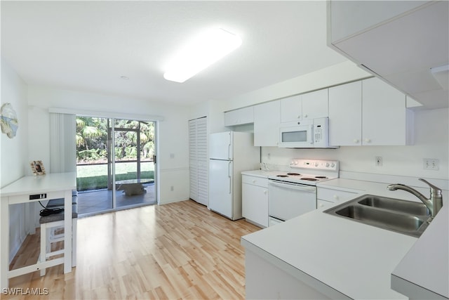 kitchen with white cabinetry, light hardwood / wood-style floors, sink, and white appliances