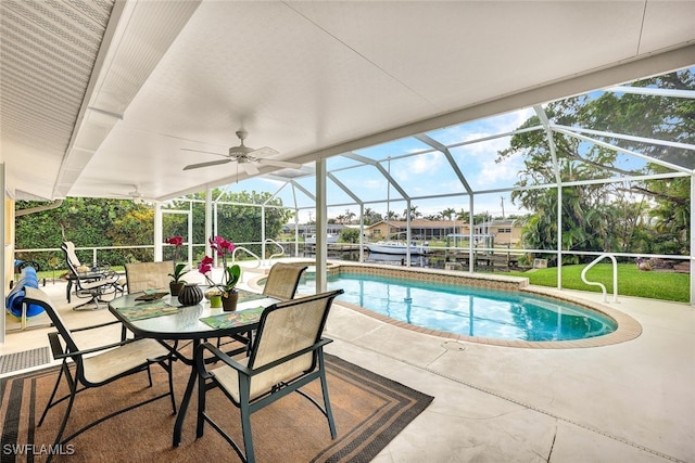 view of swimming pool featuring glass enclosure, ceiling fan, and a patio area