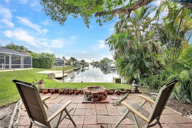 view of patio / terrace featuring a water view, a dock, a lanai, and a fire pit