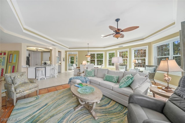 living room with light tile patterned floors, ceiling fan, and ornamental molding