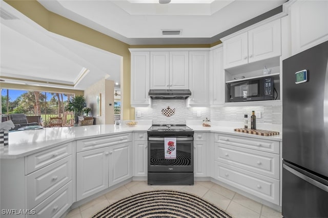 kitchen featuring a tray ceiling, kitchen peninsula, white cabinets, and appliances with stainless steel finishes