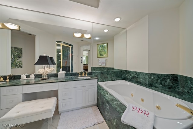 bathroom with tiled tub, tile patterned flooring, and vanity