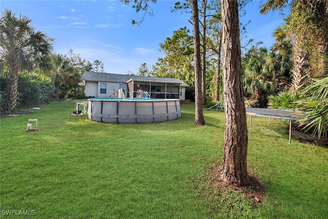 view of yard with a sunroom and a trampoline