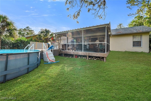 rear view of property featuring a lawn and a sunroom