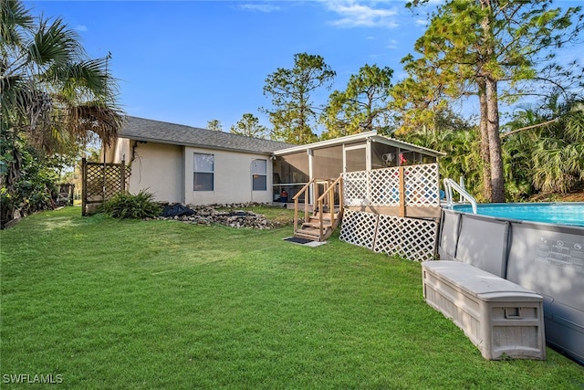 rear view of property with a lawn and a sunroom