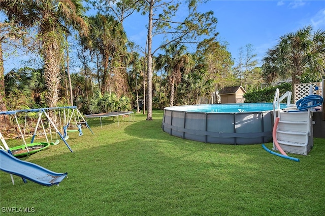 view of yard with a trampoline and a playground