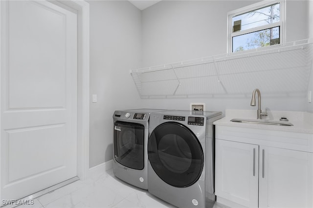 clothes washing area featuring independent washer and dryer, sink, and cabinets