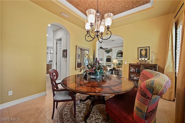 dining space featuring a raised ceiling, crown molding, light tile patterned flooring, and ceiling fan with notable chandelier