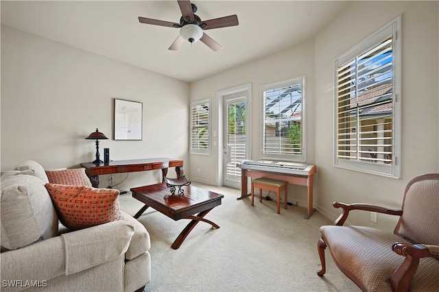 carpeted living room with ceiling fan