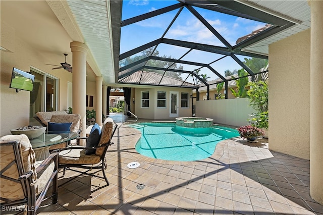 view of pool featuring glass enclosure, an in ground hot tub, a patio area, and ceiling fan