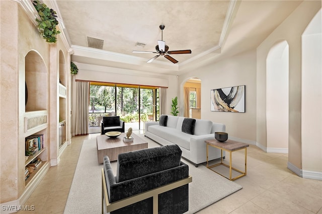 tiled living room with a raised ceiling, ceiling fan, crown molding, and a premium fireplace