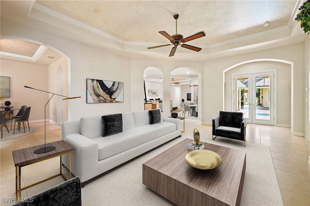 living room featuring french doors, a raised ceiling, ceiling fan, crown molding, and light tile patterned floors