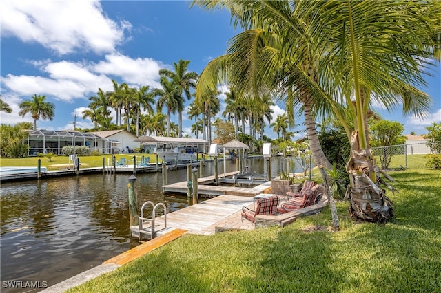 view of dock with a lawn and a water view