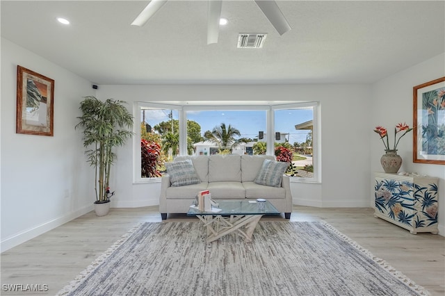 living room featuring light hardwood / wood-style flooring, a healthy amount of sunlight, and a textured ceiling