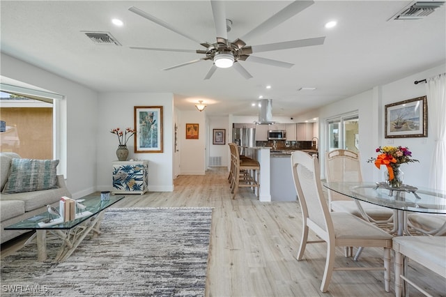 dining space featuring light wood-type flooring and ceiling fan