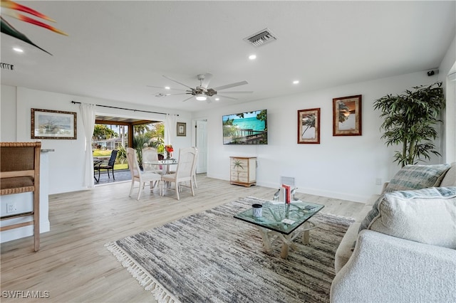 living room with ceiling fan and light wood-type flooring