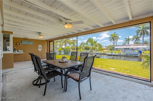 sunroom / solarium with ceiling fan, beam ceiling, and a water view