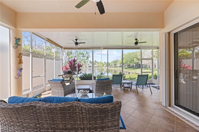 sunroom featuring a water view, ceiling fan, and plenty of natural light