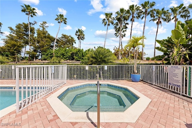 view of pool featuring a hot tub and a patio area