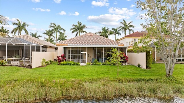 rear view of house with a sunroom, a yard, and a lanai