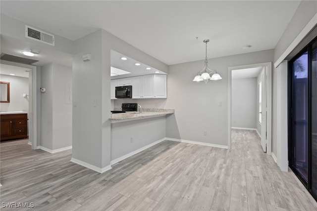 kitchen with black appliances, kitchen peninsula, light hardwood / wood-style floors, and white cabinets