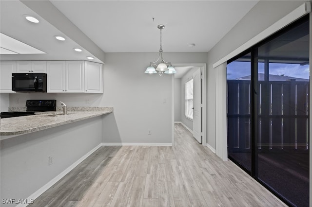 kitchen featuring light stone counters, white cabinets, black appliances, hanging light fixtures, and light hardwood / wood-style flooring