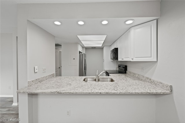 kitchen with black appliances, wood-type flooring, light stone countertops, sink, and white cabinets