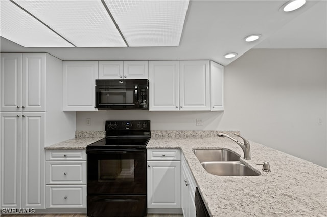 kitchen with black appliances, light stone countertops, sink, and white cabinets