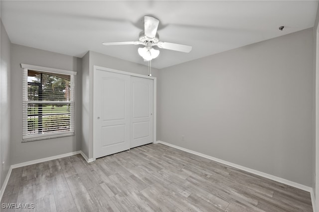 unfurnished bedroom with ceiling fan, a closet, and light hardwood / wood-style flooring