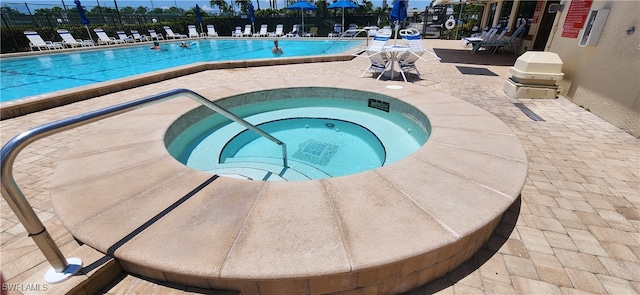 view of swimming pool with a hot tub and a patio