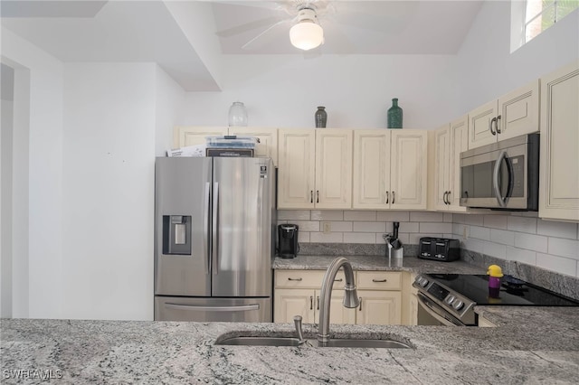 kitchen with decorative backsplash, appliances with stainless steel finishes, sink, and light stone counters