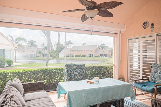 sunroom featuring a water view, ceiling fan, and vaulted ceiling