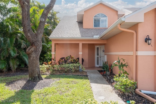 view of exterior entry with a yard