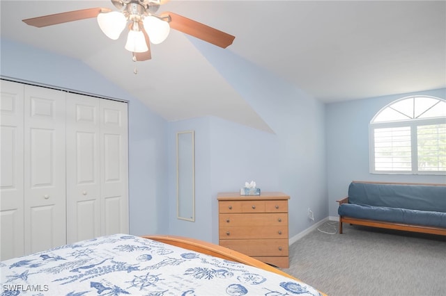 carpeted bedroom with a closet, vaulted ceiling, and ceiling fan