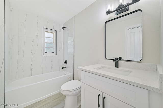 full bathroom featuring tiled shower / bath, hardwood / wood-style flooring, toilet, and vanity