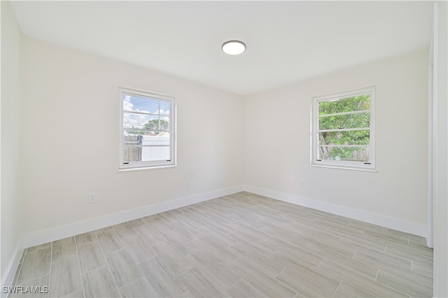 empty room with light wood-type flooring and a healthy amount of sunlight