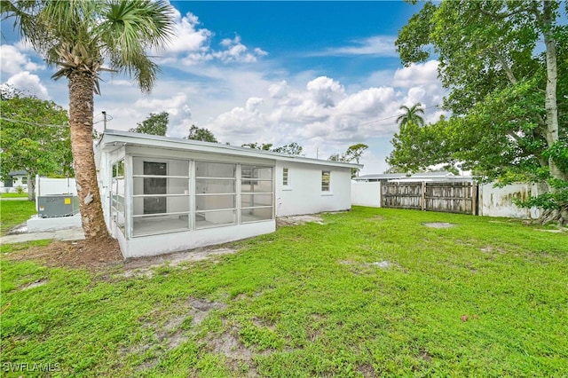 back of property featuring a sunroom and a yard