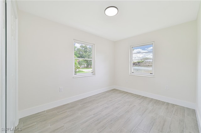 spare room with light hardwood / wood-style floors and a healthy amount of sunlight