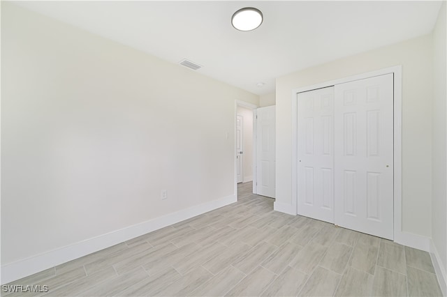 unfurnished bedroom with a closet and light hardwood / wood-style flooring