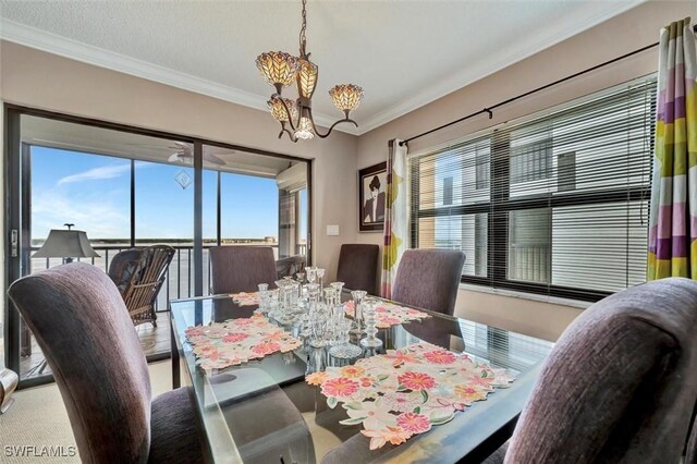 dining space featuring a notable chandelier, a healthy amount of sunlight, and ornamental molding