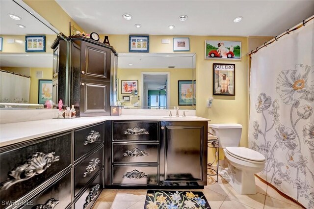 bathroom featuring toilet, vanity, and tile patterned flooring