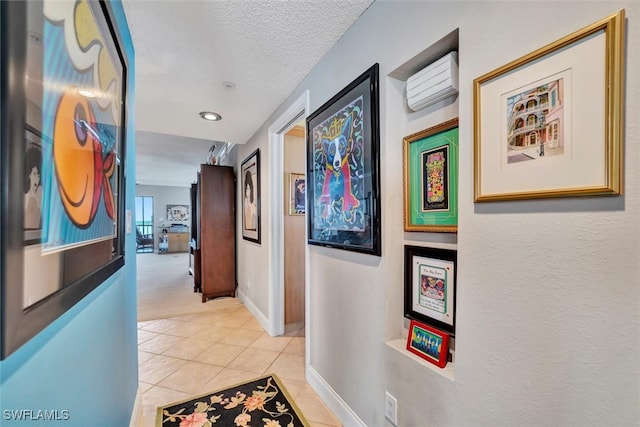 hall featuring light tile patterned flooring and a textured ceiling