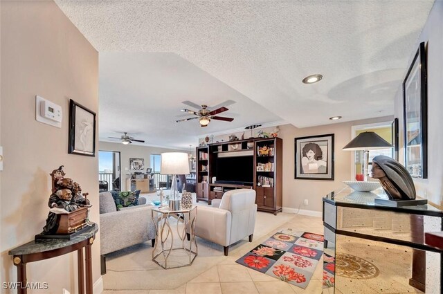 tiled living room with ceiling fan, a textured ceiling, and a healthy amount of sunlight