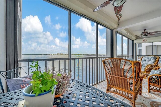 sunroom / solarium with ceiling fan, a water view, and a wealth of natural light