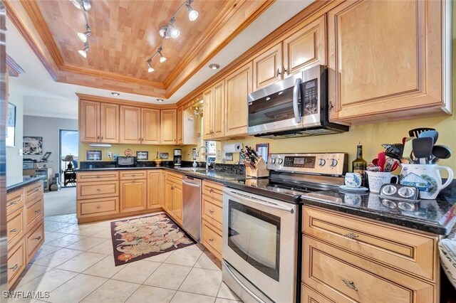 kitchen with appliances with stainless steel finishes, light brown cabinetry, sink, ornamental molding, and a raised ceiling